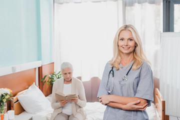 Fototapeta premium nurse and senior patient with book
