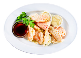 Delicious and appetizing tempura-fried vegetables served with soy sauce in a white plate isolated on white background. Autumn menu in an Italian restaurant. Top view, flat, overhead
