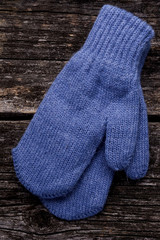 Blue mittens on wood background