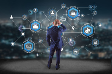 Businessman in front of a wall with an International business network connection displayed on a futuristic interface with technology icon and sphere globe - Worldwide business concept