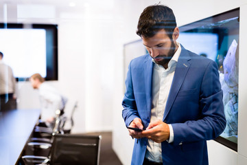 Portrait of young businessman using mobile phone