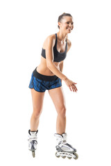 Rollerskating young adult woman in sportswear laughing and looking away. Full body length portrait isolated on white studio background. © sharplaninac