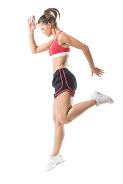 Side view of sporty focused confident fitness woman jumping movement. Full body length portrait isolated on white studio background.