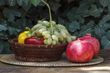 - Grapes in a wicker basket against a background of green ivy