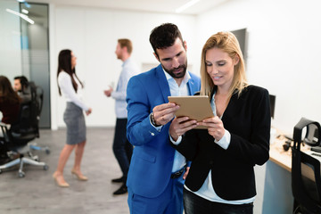 Attractive business couple using tablet in their company