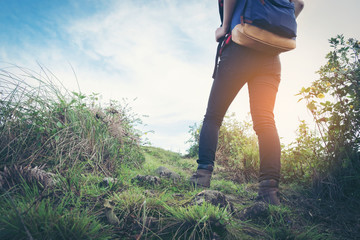 View of hiker legs walking on a path. Active woman backpacker traveling on the nature.
