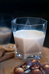 irish cream liqueur in a glass glass served with walnuts, wafer rolls and chocolate