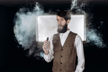 Young man with beard vaping an electronic cigarette outdoor. hipster smoke vaporizer.