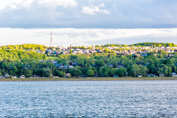 Cityscape skyline of Levis, Quebec, Canada during sunset with many houses on shore with water waves