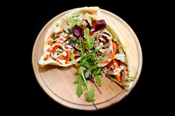 Stuffed with meat, tomato, onion, pepper, green beans, greens, basil, dressed with sauce and served on a wooden board