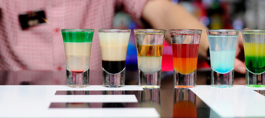 Short cocktails of different colors stand on the bar