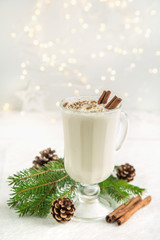 traditional winter eggnog cocktail with whipped cream and cinnamon for Christmas