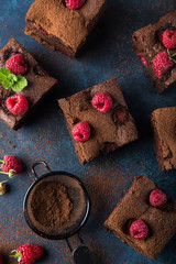 raspberry brownies served  with fresh berries on blue background