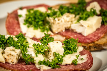 slice of bread with salami parsley and cheese