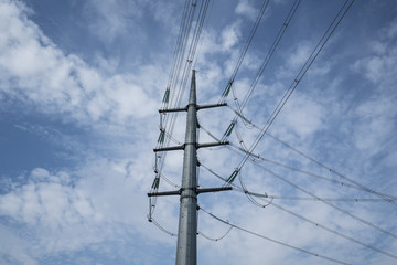 high voltage trellis with clouds in the sky in the background	