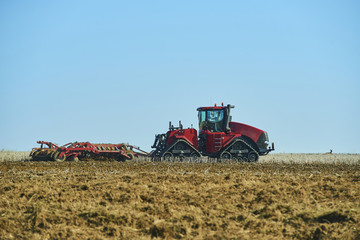 Seasonal work in a agricultural landscape. Tractor plowing the field.