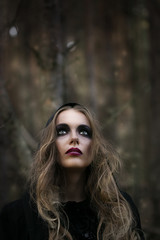 Fototapeta na wymiar Halloween. beautiful girl witches in the woods with pumpkins