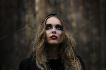 Halloween. beautiful girl witches in the woods with pumpkins