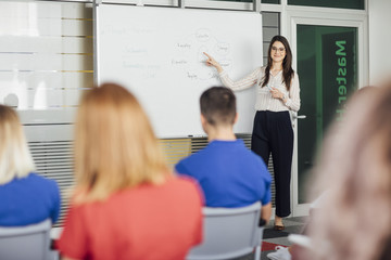 Teacher Explaining Chart on Whiteboard