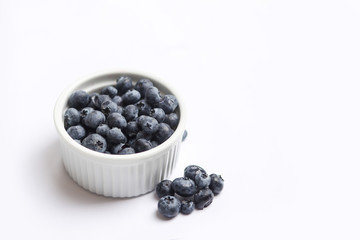 Fresh cup of blueberries isolated on white background