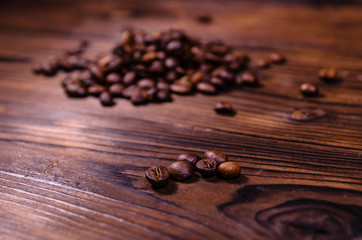Pile of the roasted coffee beans on wooden table