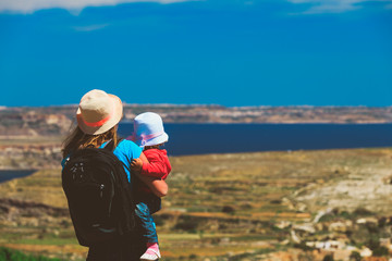 mother with little daughter travel hiking in mountains