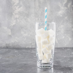 Glass with sugar cubes is an unhealthy diet. The contents of sugar in sweet soda.