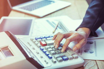 Business woman putting her hand on calculator, business and investment concept