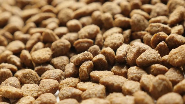  Shallow DOF pile of cat or dog pellet meal - Brown pet dry food close-up slow tilt
