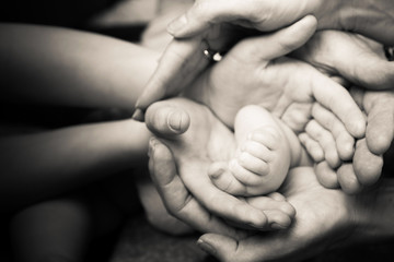Baby's leg in the hands of parents