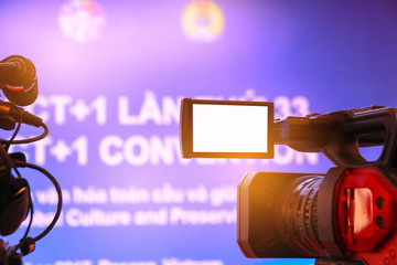 Blur of Video camera or camcorder operator working his camera equipment for record in conference...