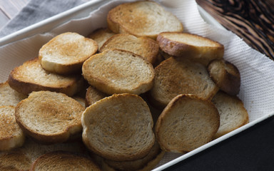 Toasts, fried bread in a plate on wood background