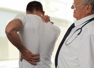 Muscular Man suffering from back and neck pain. Incorrect sitting posture problems Muscle spasm, rheumatism. Pain relief, ,chiropractic concept. Sport exercising injury
