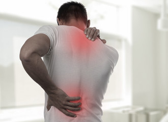 Muscular Man suffering from back and neck pain. Incorrect sitting posture problems Muscle spasm, rheumatism. Pain relief, ,chiropractic concept. Sport exercising injury