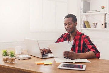 Obraz na płótnie Canvas Happy black happy businessman in office, work with laptop