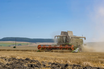 Close-up of a working harvester's at harvest time. A dust and straw fertilizer. Concept farming and agriculture. Copy space.