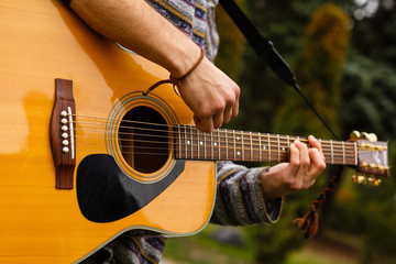 Obraz premium Young musician playing acoustic guitar close up