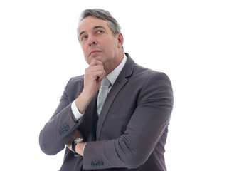 Gray-haired man is looking up and thinking. Executive in suit on white background..