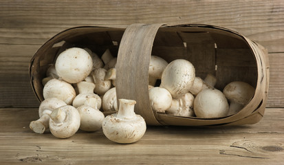Basket with mushrooms on wooden background