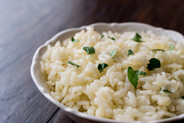 Bowl of  Cooked Rice on dark wooden surface.