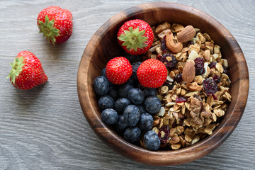Homemade  granola with  fresh berry in wooden bowl