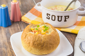 Homemade corn and cheese chowder in bread bowl.
