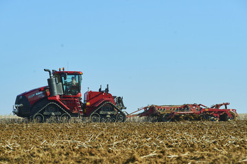 Seasonal work in a agricultural landscape. Tractor plowing the field.