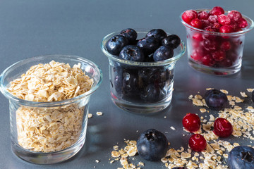 granola, oatmeal and fresh juicy berries cranberries and blueberries, concept of vegetarian healthy eating