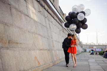 Young and cute couple walks along the promenade