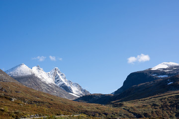 Mountain scenery with snow on the high peaks against blue sky background