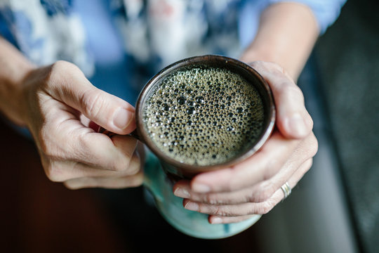 Holding warm home brewed coffee drink