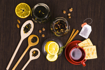 Wooden spoon with tea and lemon on a dark tablecloth