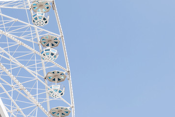 White ferris wheel over blue sky - background