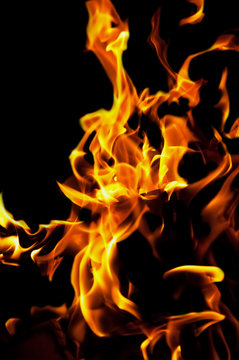 The yellow flame fire on a black isolated background.